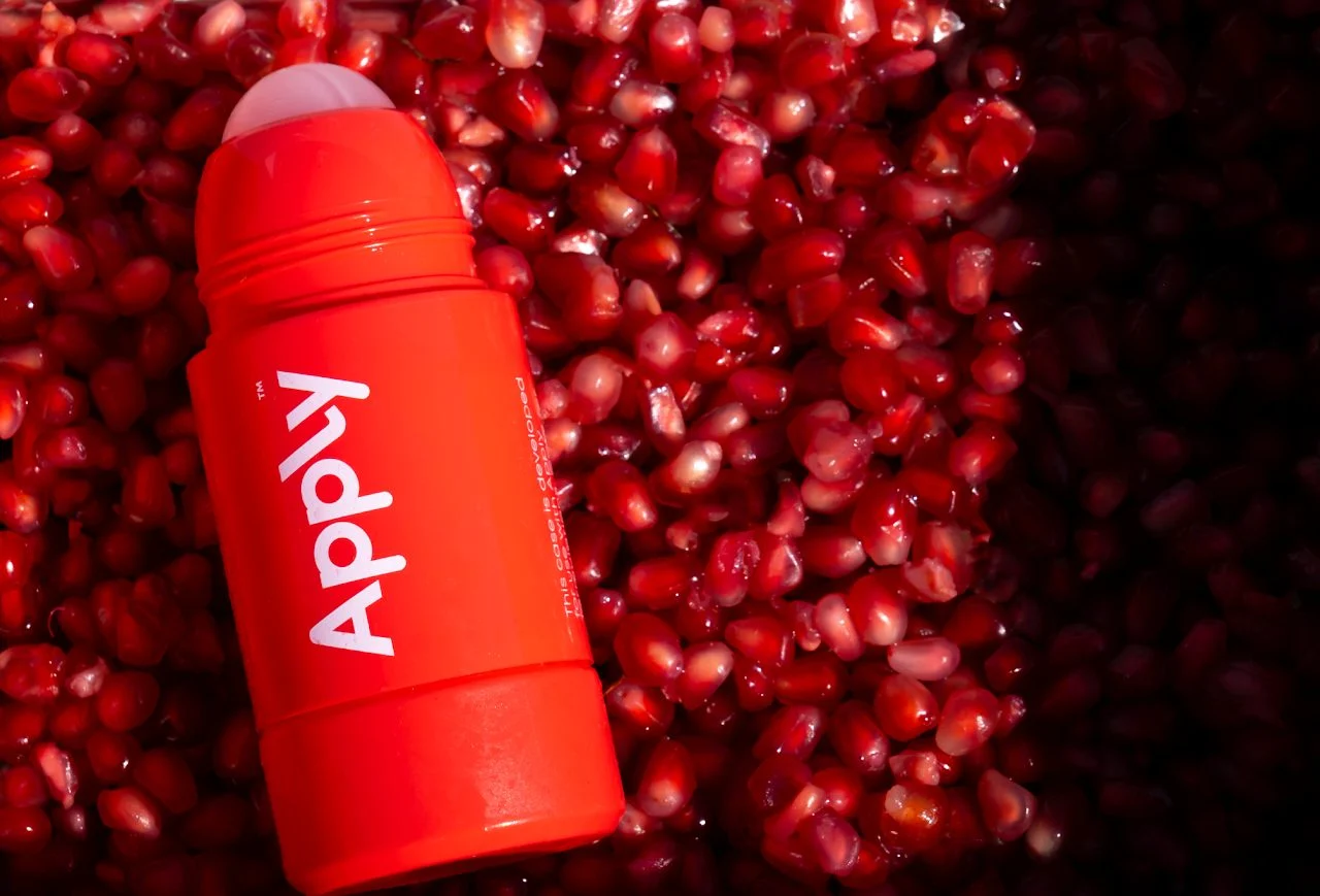 An Apply roll-on lying on pomegranate seeds
