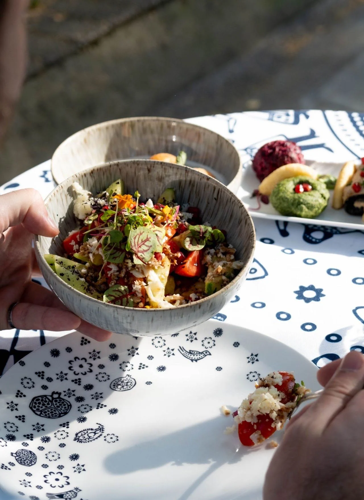 A salad held over the patterned tablecloth